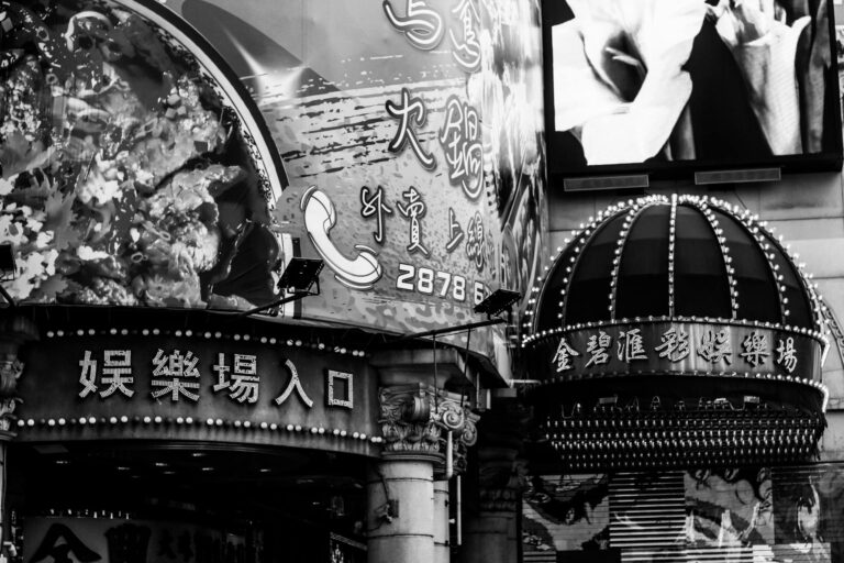 A bustling city scene with illuminated signs and advertisements captured in black and white.